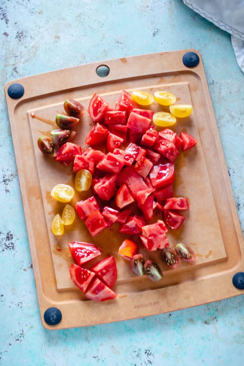 Sliced red, yellow, and purple tomatoes on a cutting board
