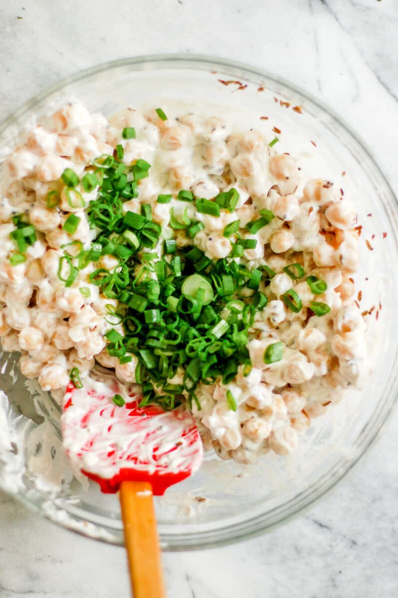 Chickpeas in yogurt with a bunch of sliced scallions on top