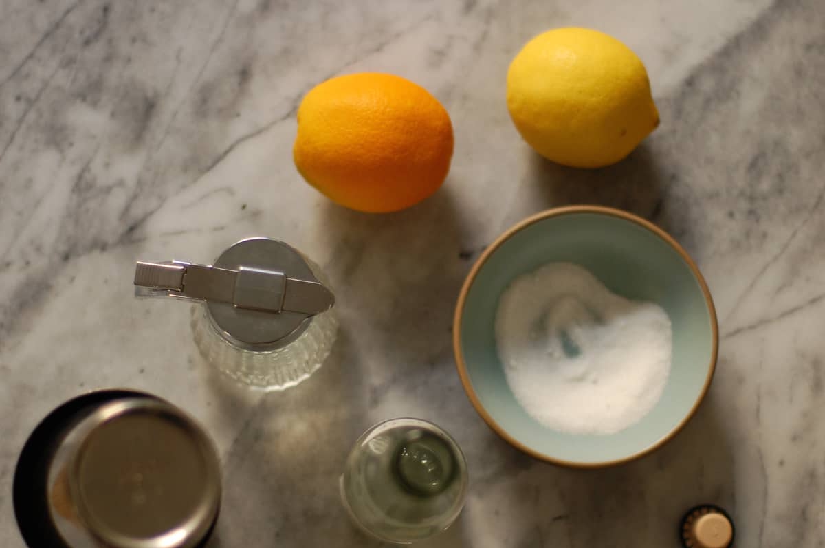 Simple syrup, orange, lemon, and bowl with sugar