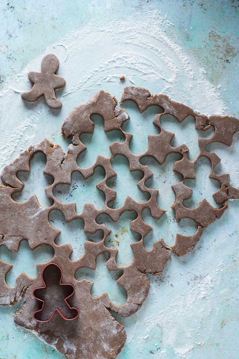Gingerbread cookie dough, rolled out with gingerbread men cutouts