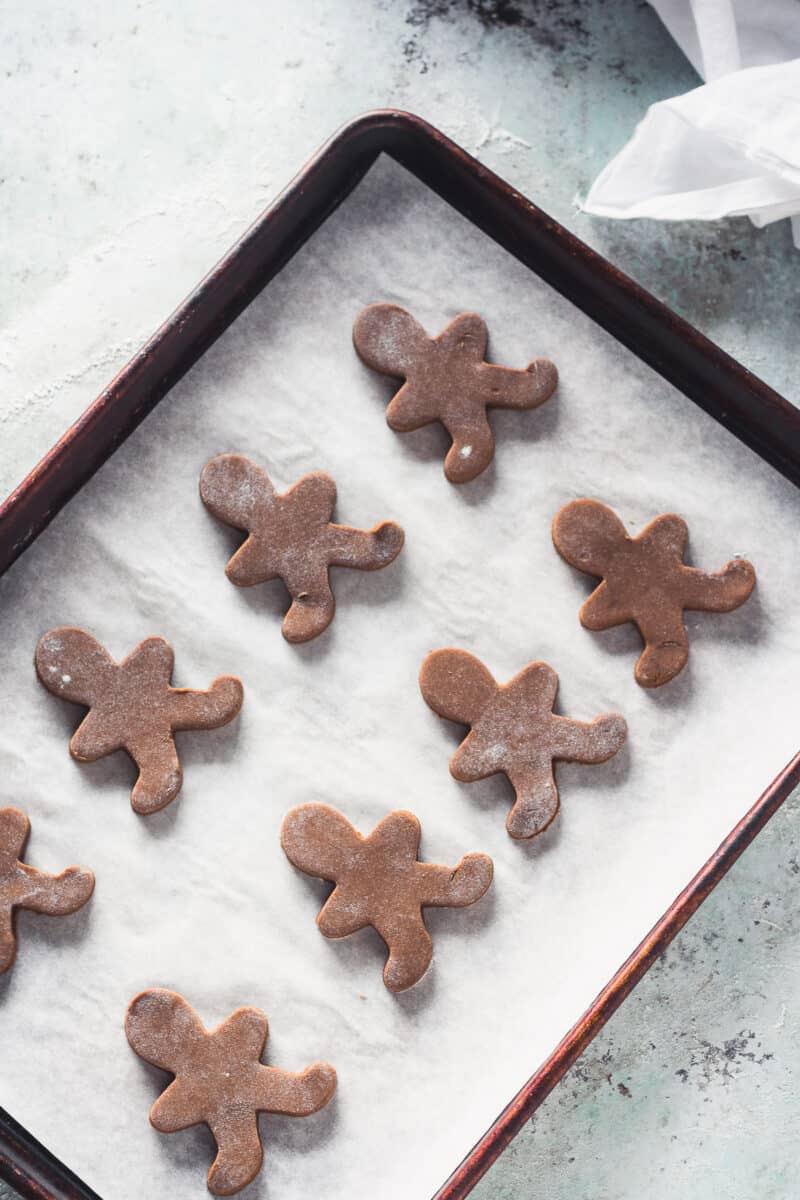 Gingerbread men on a baking sheet waiting for decoration