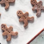 Cut-out gingerbread men dough on a baking sheet