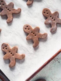 Cut-out gingerbread men dough on a baking sheet