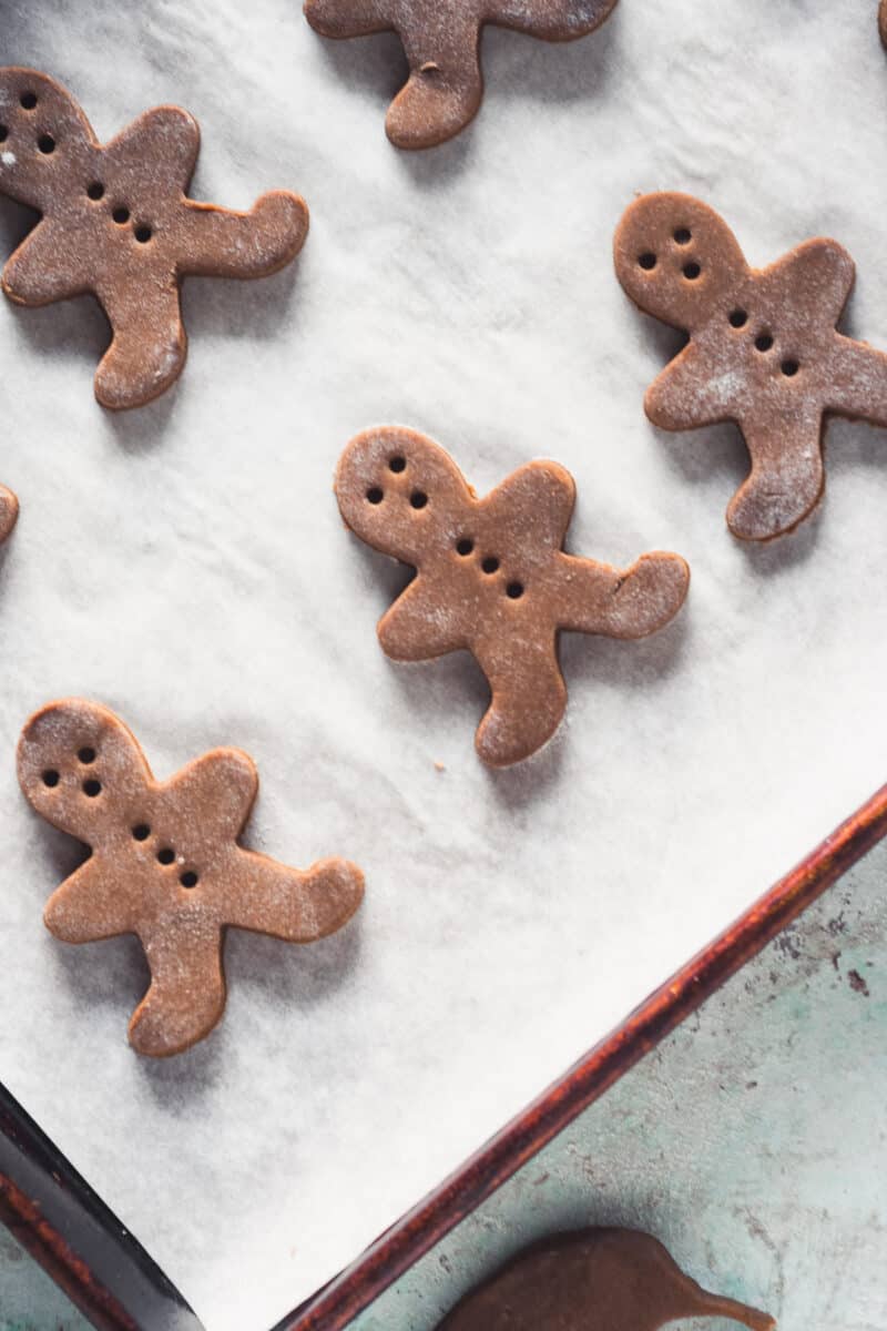 Cut-out gingerbread men dough on a baking sheet