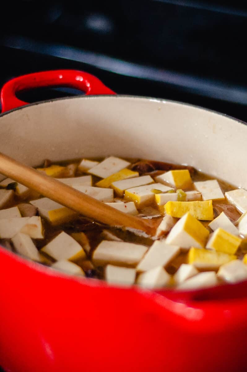 Tofu in hot and sour soup in a red Dutch oven