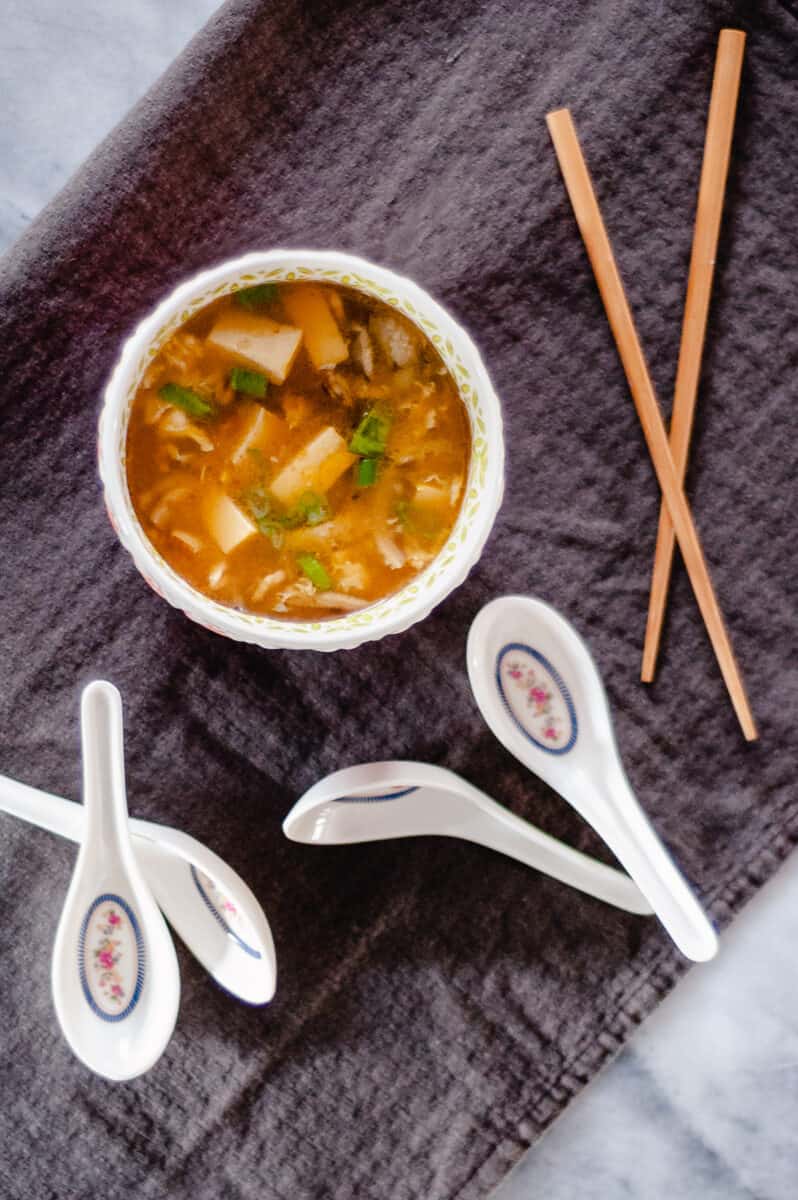 Hot and Sour Soup with spoons and chopsticks