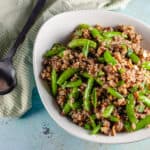 Sugar Snap Pea and Cashew Quinoa in a n oval serving bowl with a serving spoon next to it