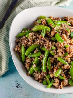 Sugar Snap Pea and Cashew Quinoa in a n oval serving bowl with a serving spoon next to it