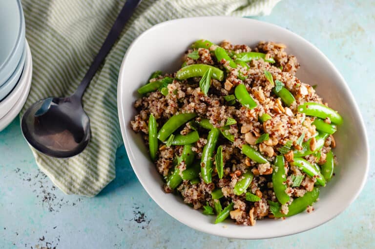 Sugar Snap Pea and Cashew Quinoa in a n oval serving bowl with a serving spoon next to it