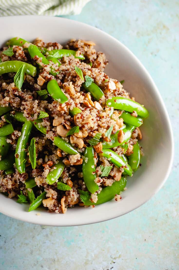 Sugar snap pea and cashew quinoa salad in a serving bowl, closeup