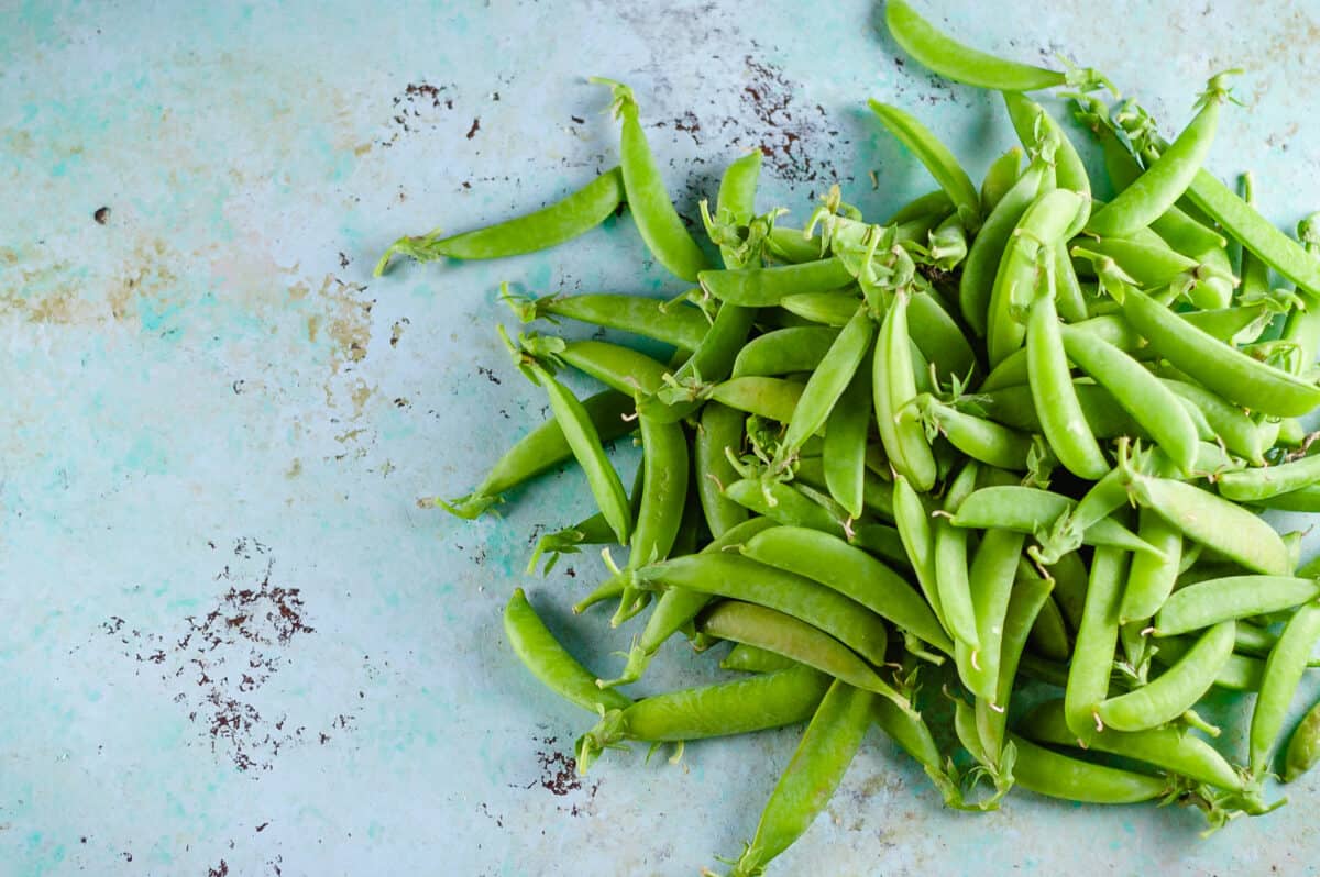 Sugar snap peas piled on a counter