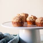 Cinnamon Sugar Oat Muffins on a white cake stand