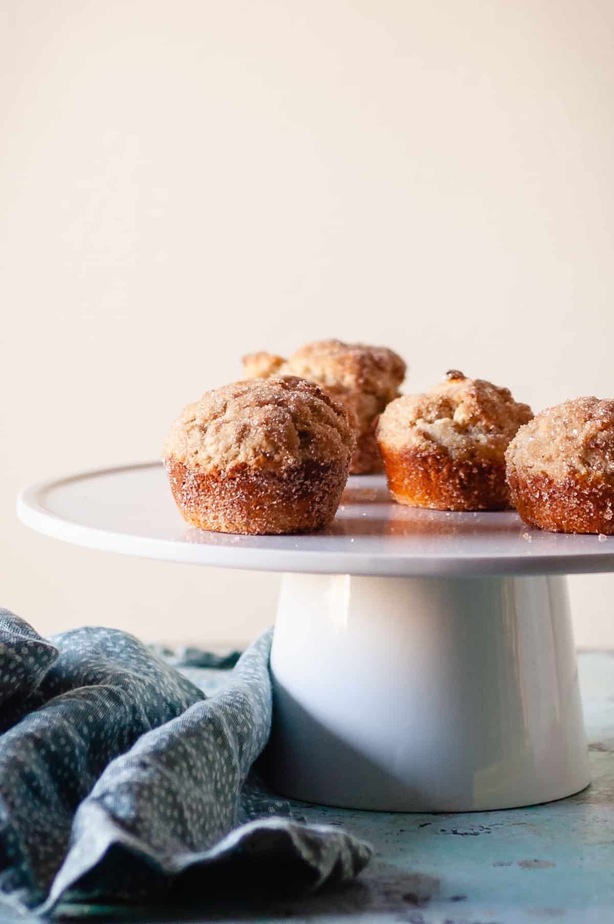Cinnamon Sugar Oat Muffins on a white cake stand