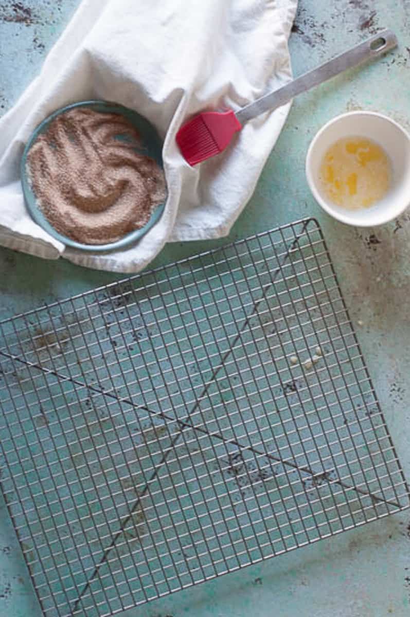 Cinnamon and sugar and melted butter next to a cooling rack