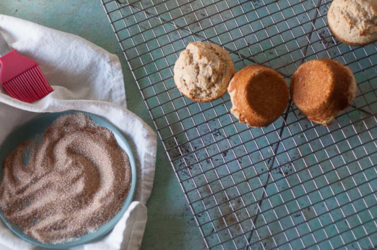 Cinnamon sugar next to warm muffins