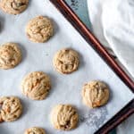 Chocolate butterscotch chip cookies on a parchment lined sheet pan