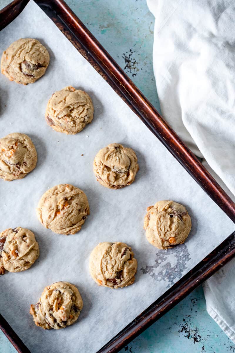 Chocolate butterscotch chip cookies on a parchment lined sheet pan