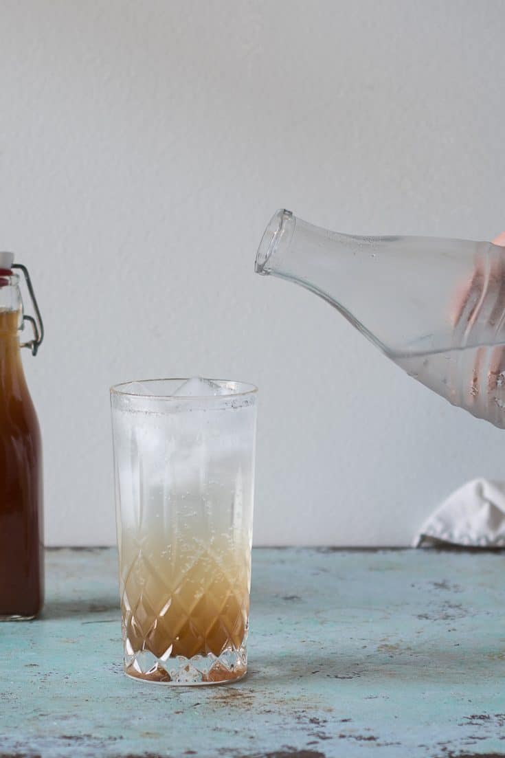 Adding soda water to ginger syrup to make ginger ale