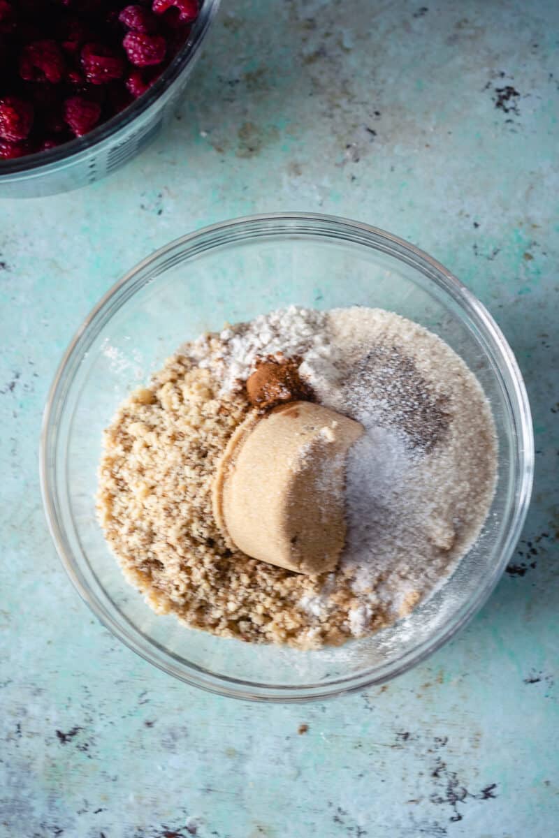 Brown sugar, flour, walnuts and spices in a clear bowl