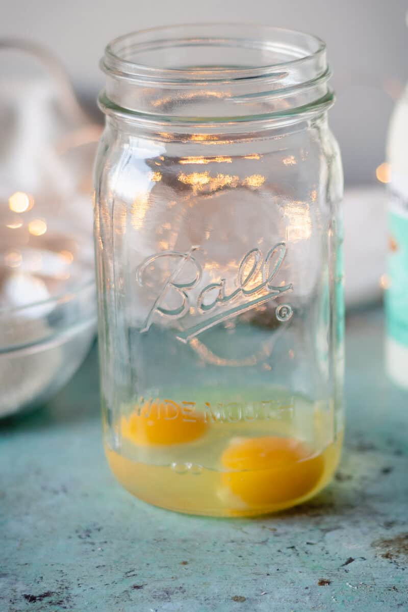 Two eggs cracked in a mason jar