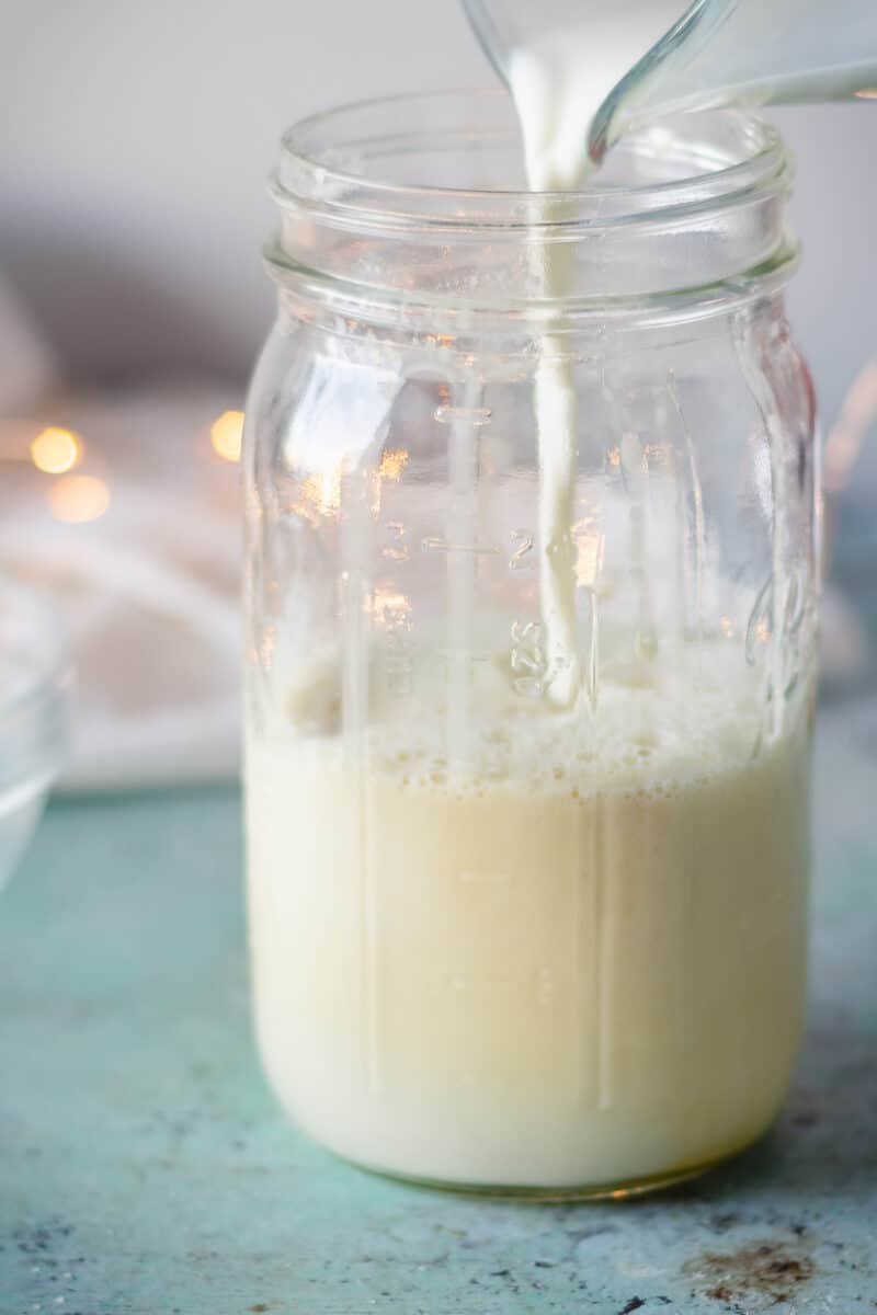 Half and half pouring into jar over egg mixture