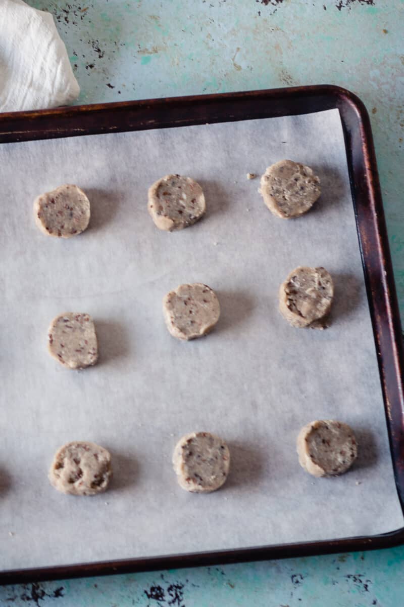 Unbaked nibby buckwheat cookies on a sheet pan