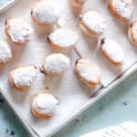 Paczki on a paper towels on a sheet pan