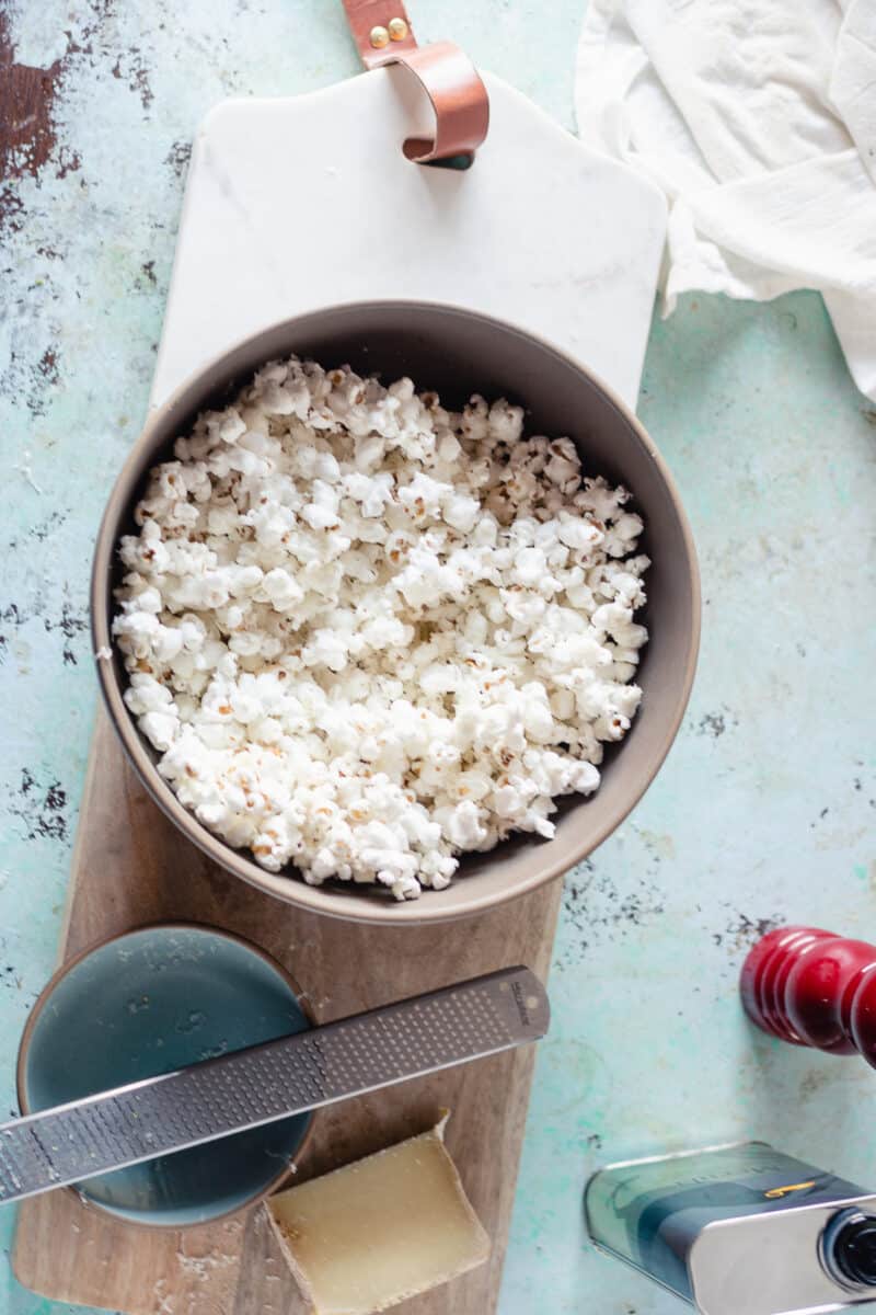 Cacio e pepe popcorn in a bowl on a serving board