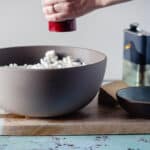 Pepper grinder over a bowl of popcorn