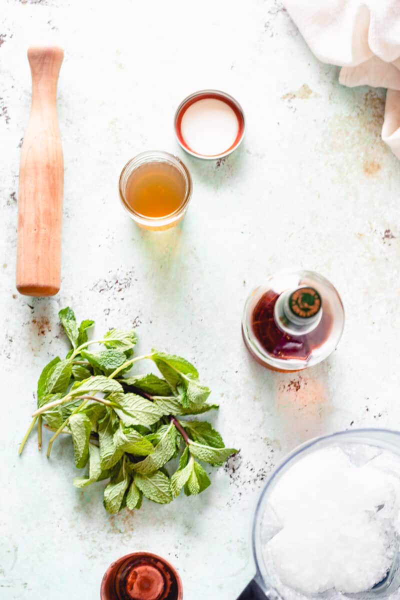 Simple syrup, mint, bourbon, crushed ice in a blender, wooden muddler