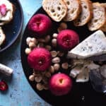 Cranberry Lapsang Poached Apples on a plate with cheese, almonds, and toast