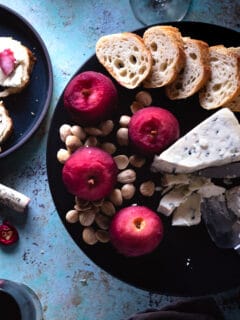 Cranberry Lapsang Poached Apples on a plate with cheese, almonds, and toast