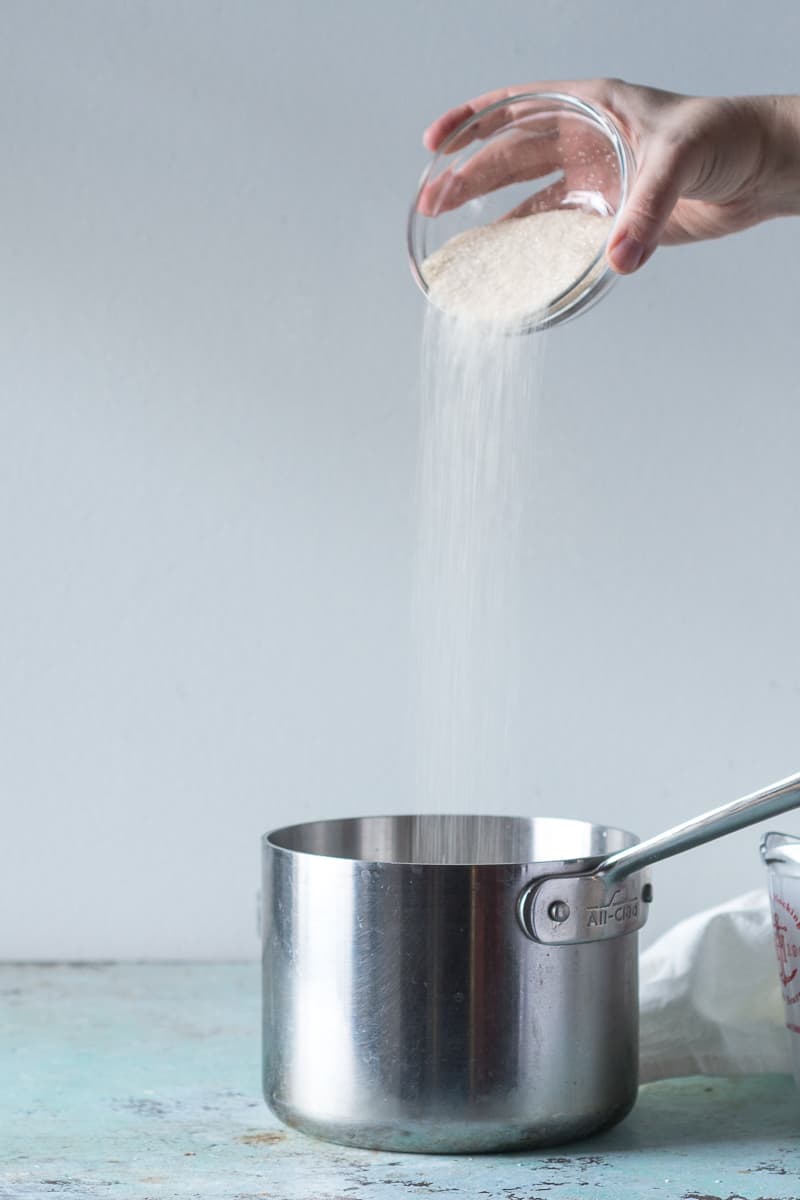 Pouring sugar into a sauce pan