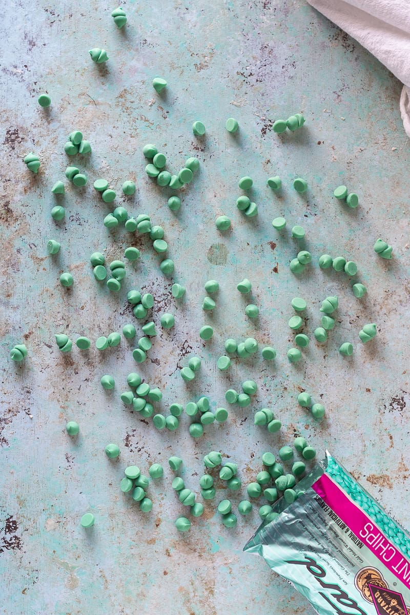 Green mint chips scattered on a blue background