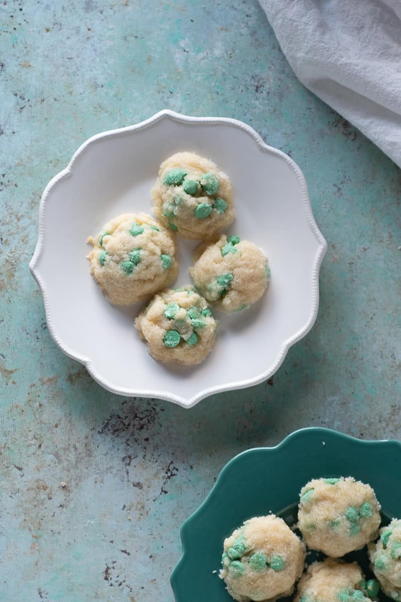 Mint chip cookies on a white plate with some more cookies on a green plate nearby
