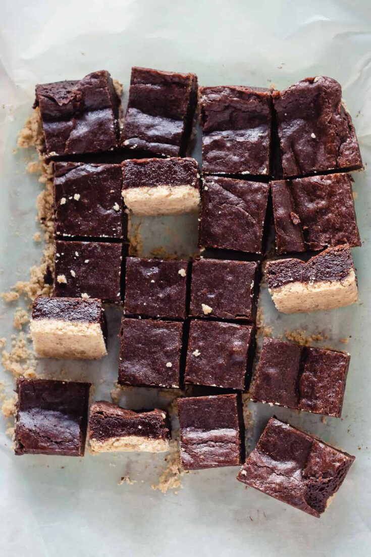 Sliced almond shortbread brownies with a few turned sideways to show the layers of shortbread crust and brownie topping