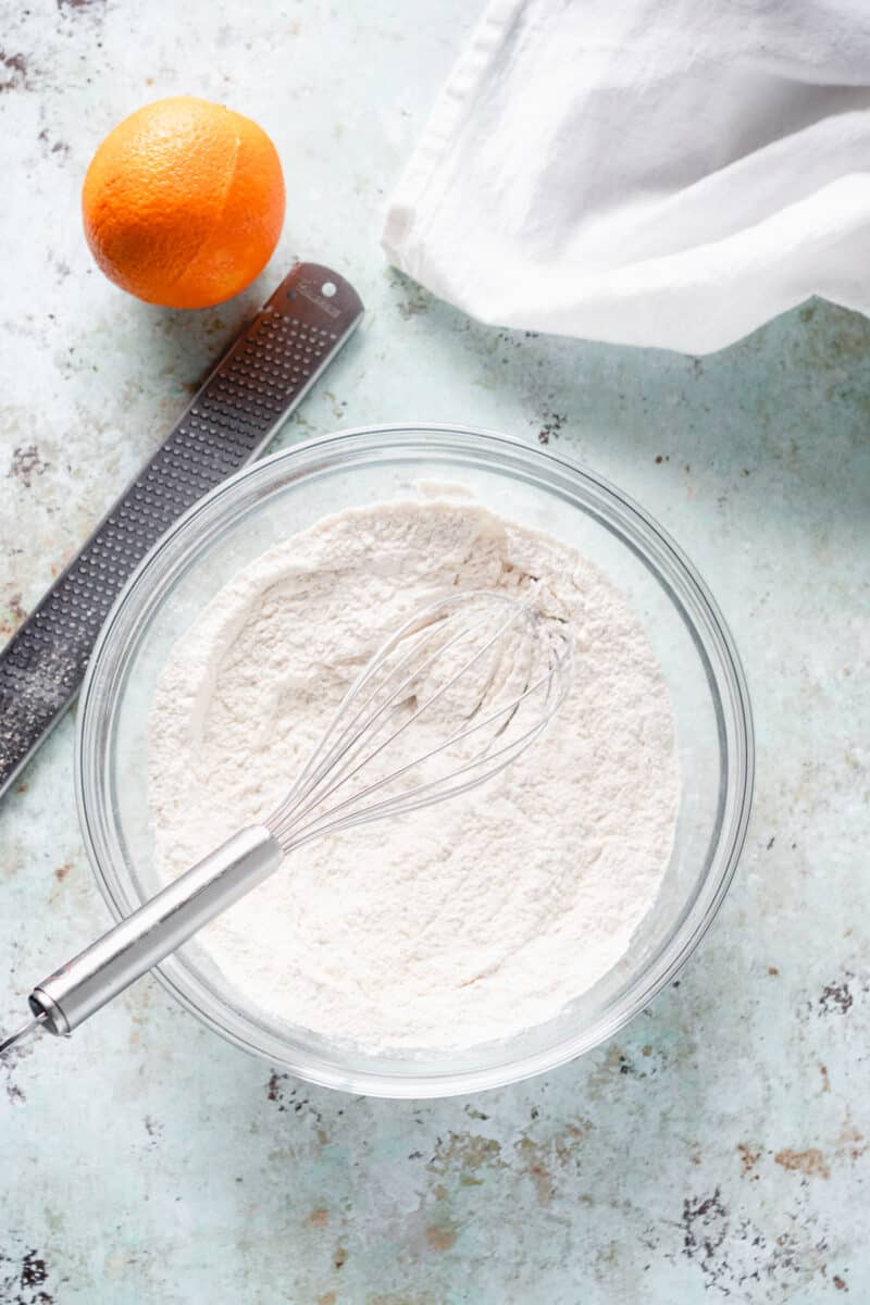 Flour mixture with a whisk and an orange alongside