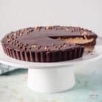 Chocolate Peanut Butter Tart on a white cake stand