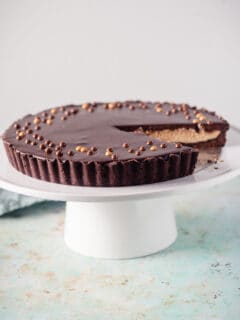 Chocolate Peanut Butter Tart on a white cake stand