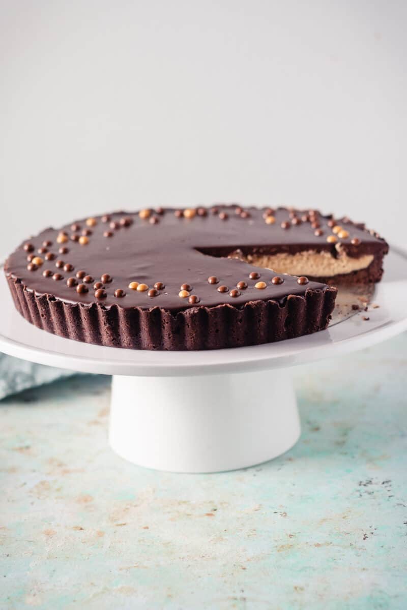 Chocolate Peanut Butter Tart on a white cake stand