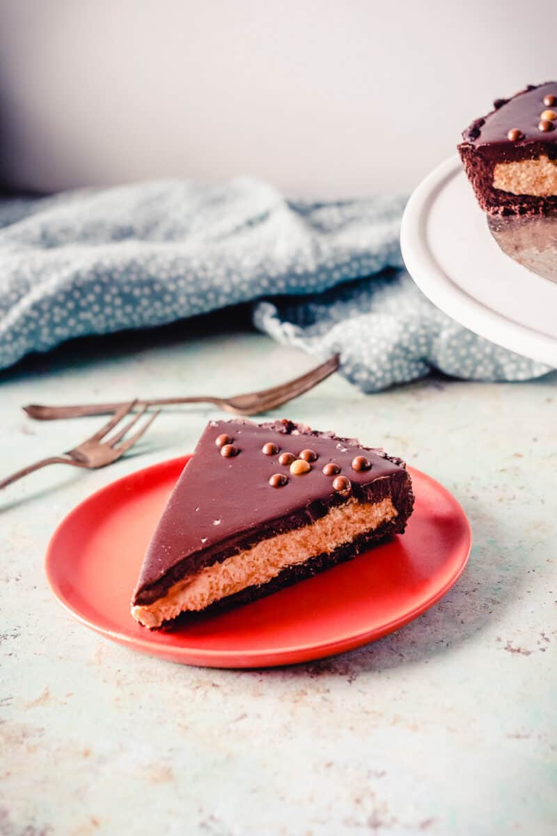 Slice of chocolate peanut butter tart on a red plate