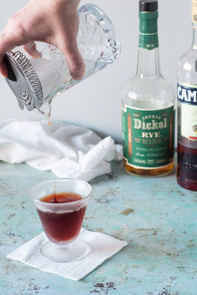 Pouring the last drop of the cocktail into the glass