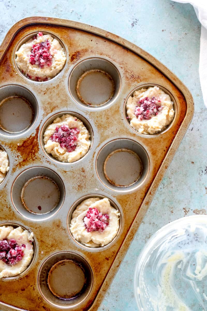 Raspberry lemon muffins in a muffin tin before baking