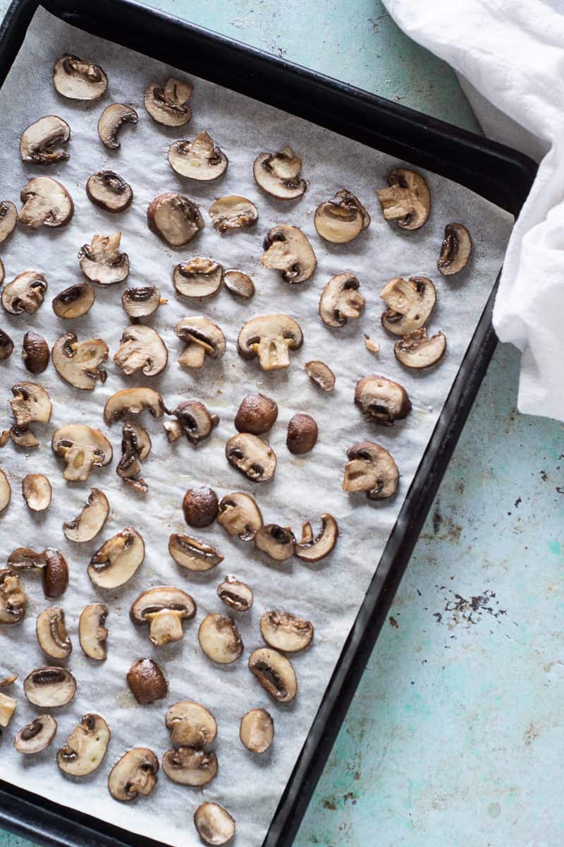Roasted sliced cremini mushrooms on a sheet pan