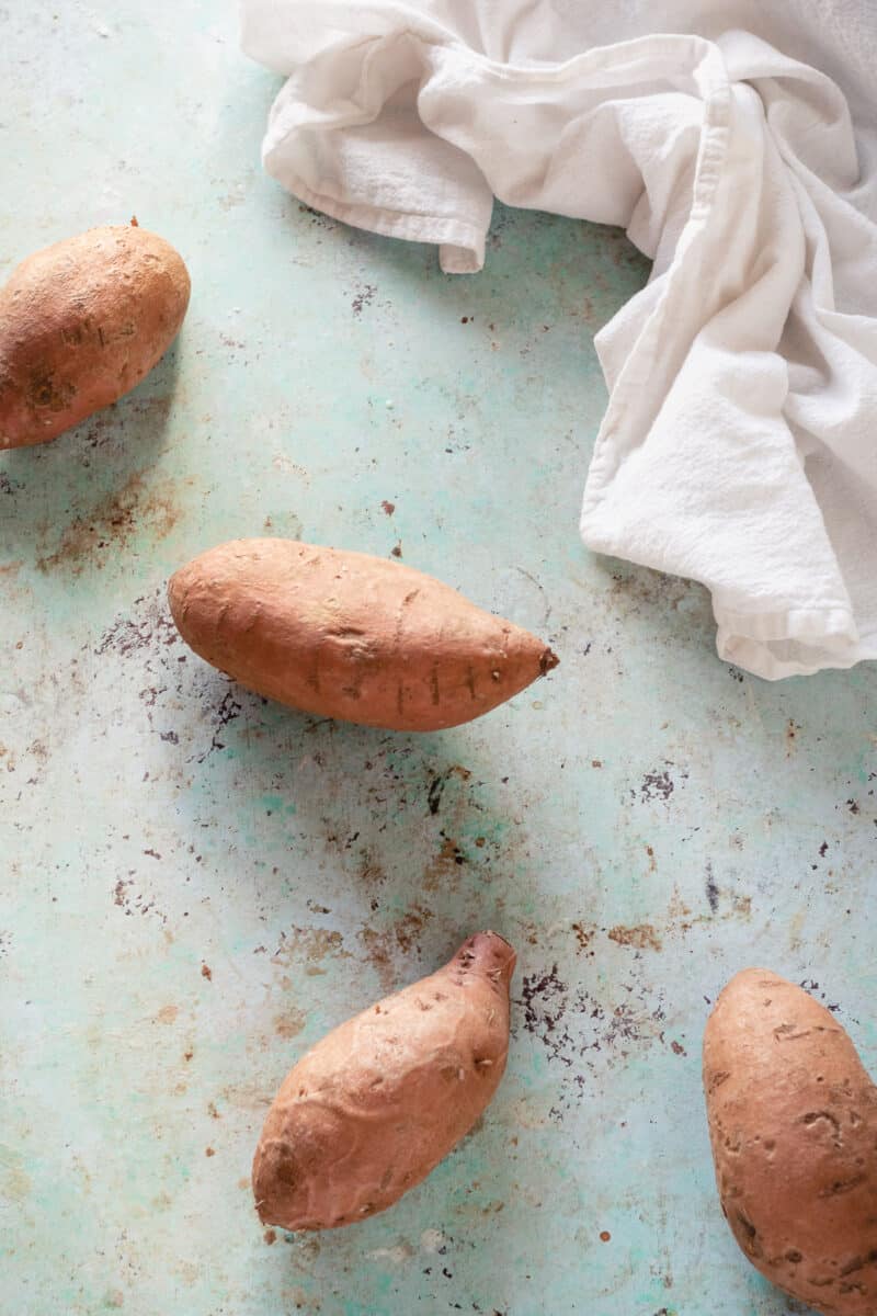 Four sweet potatoes on a counter