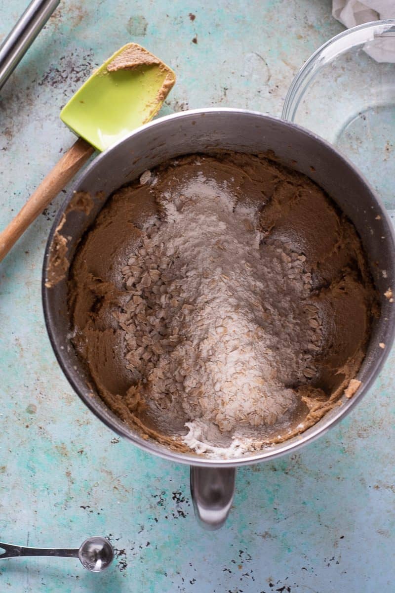 Dry ingredients added to the wet ingredients in the bowl of a stand mixer