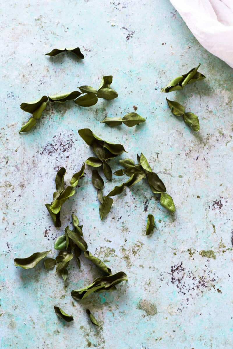 Makrut lime leaves scattered on a counter