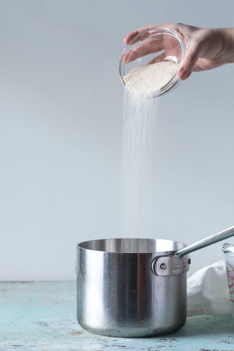 Pouring sugar into saucepan