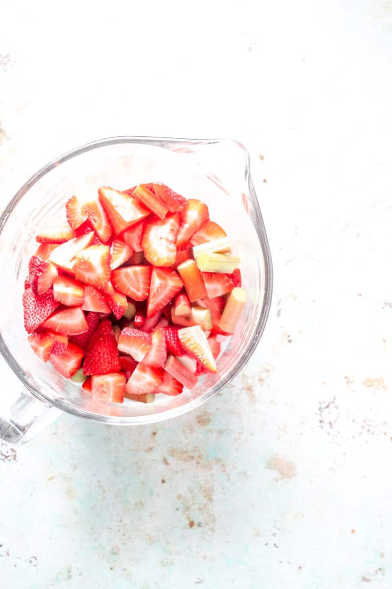 Slice strawberries and rhubarb in a bowl