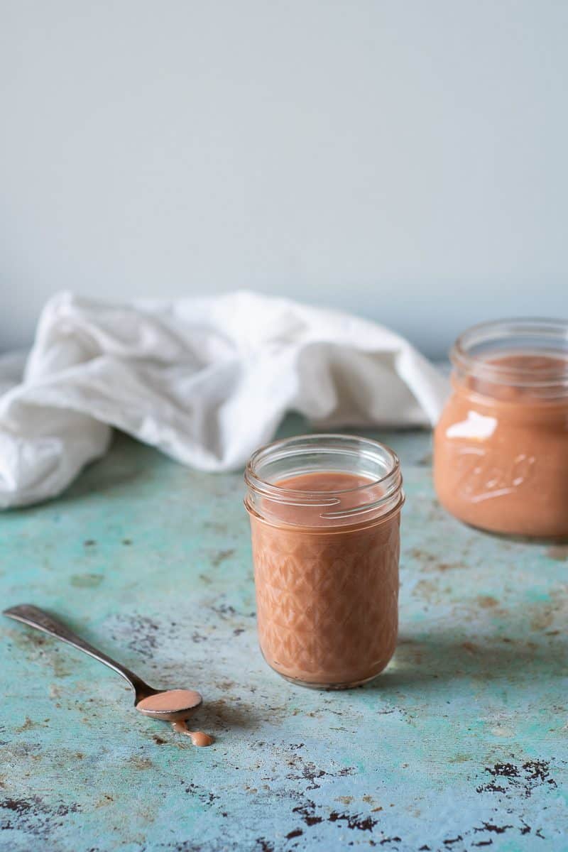 Rhubarb curd in jars and mounded on a spoon